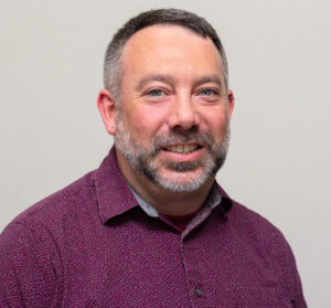 Headshot of man with purple button up shirt