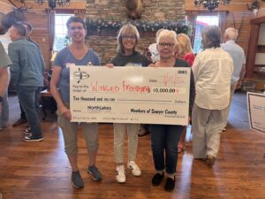 Three women holding a check.